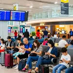 Travelers at airport checking AA88 flight details amidst bustling crowds.